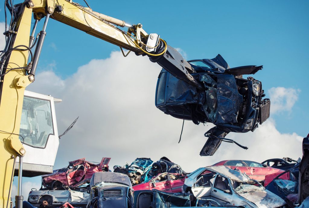 Car being carried by machinery in scrap yard. Williams Metal Recycling. Scrap Metall. Car Collections. Scrap Metal. Pewsey, Wiltshire.